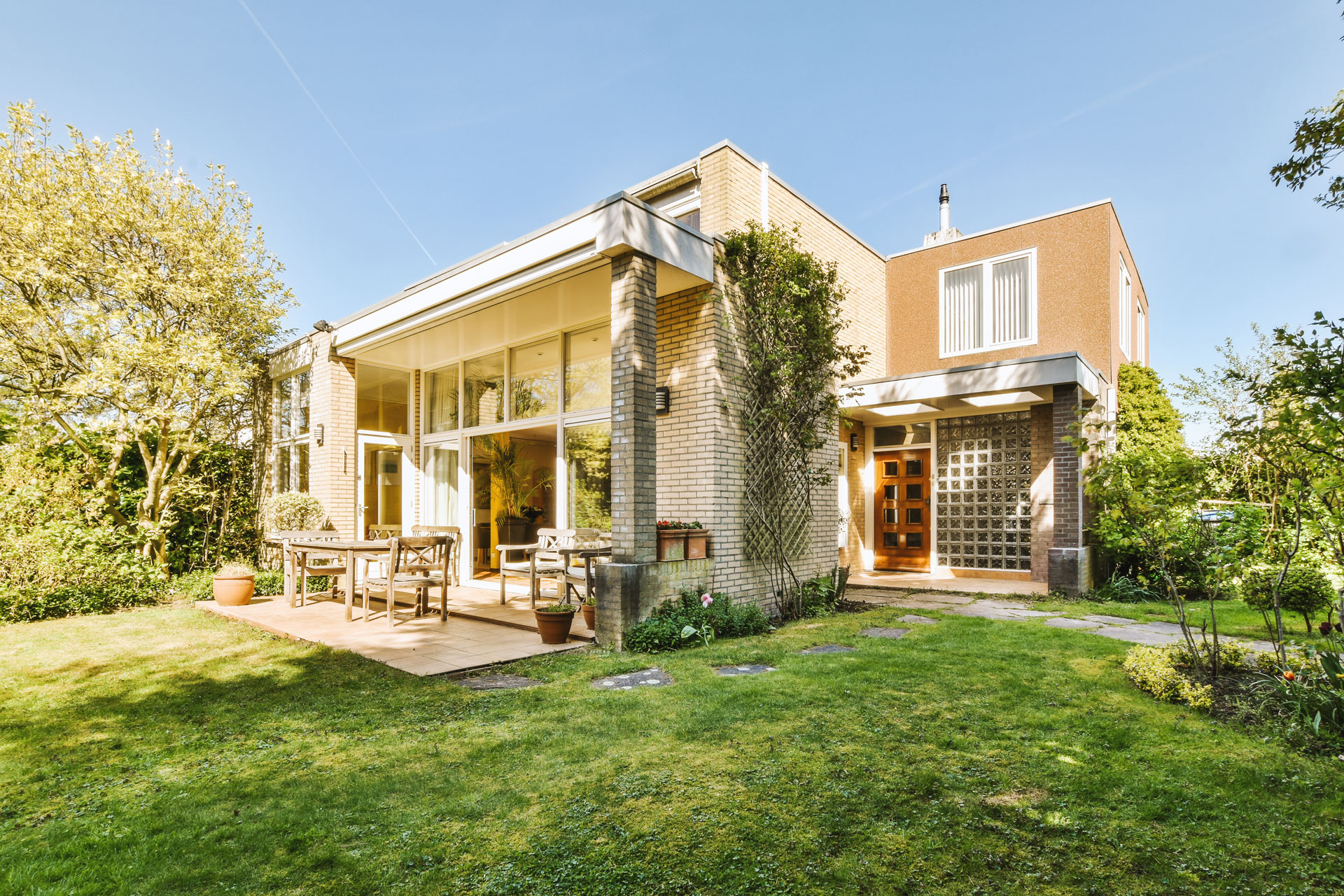 Panoramic view of a brick house during summer weather.