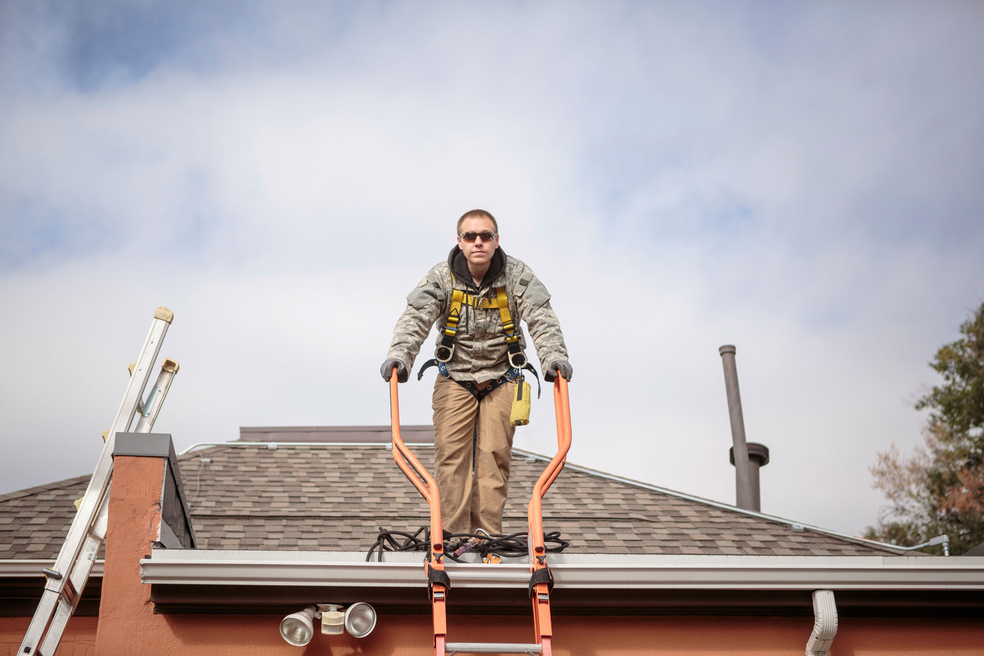A man standing on roof for roof inspection.