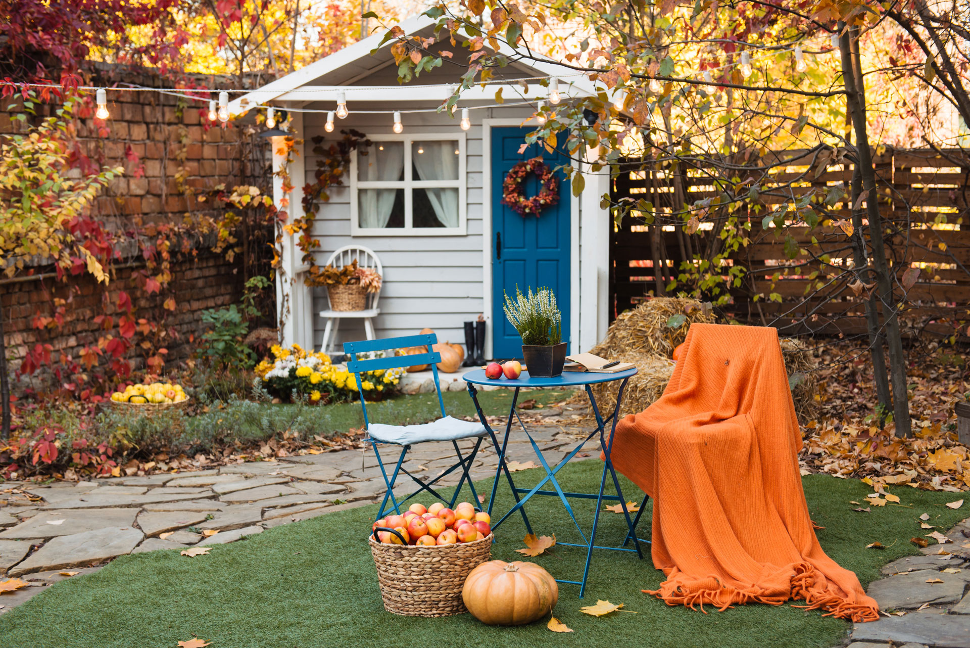 Backyard with table and a chair. pumpkin, apples in a basket during autumn.