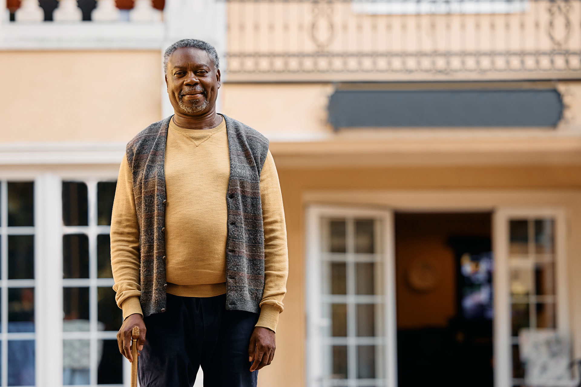 Elderly man in front of his house.